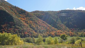A mountainous landscape with autumn foliage, a clear sky, and a distant view of a valley. - Snowshoe or ski and relax by a warm wood stove while playing games! (Scofield)