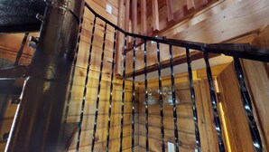 Un intérieur en bois avec une rampe d’escalier en métal.