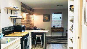 A compact kitchen with a wooden countertop, a stove, and a sink. There is a stool and a rug on the floor. - Vacay Getaway! Cozy Coastal South Bay Blue Bungalow (Rockport)