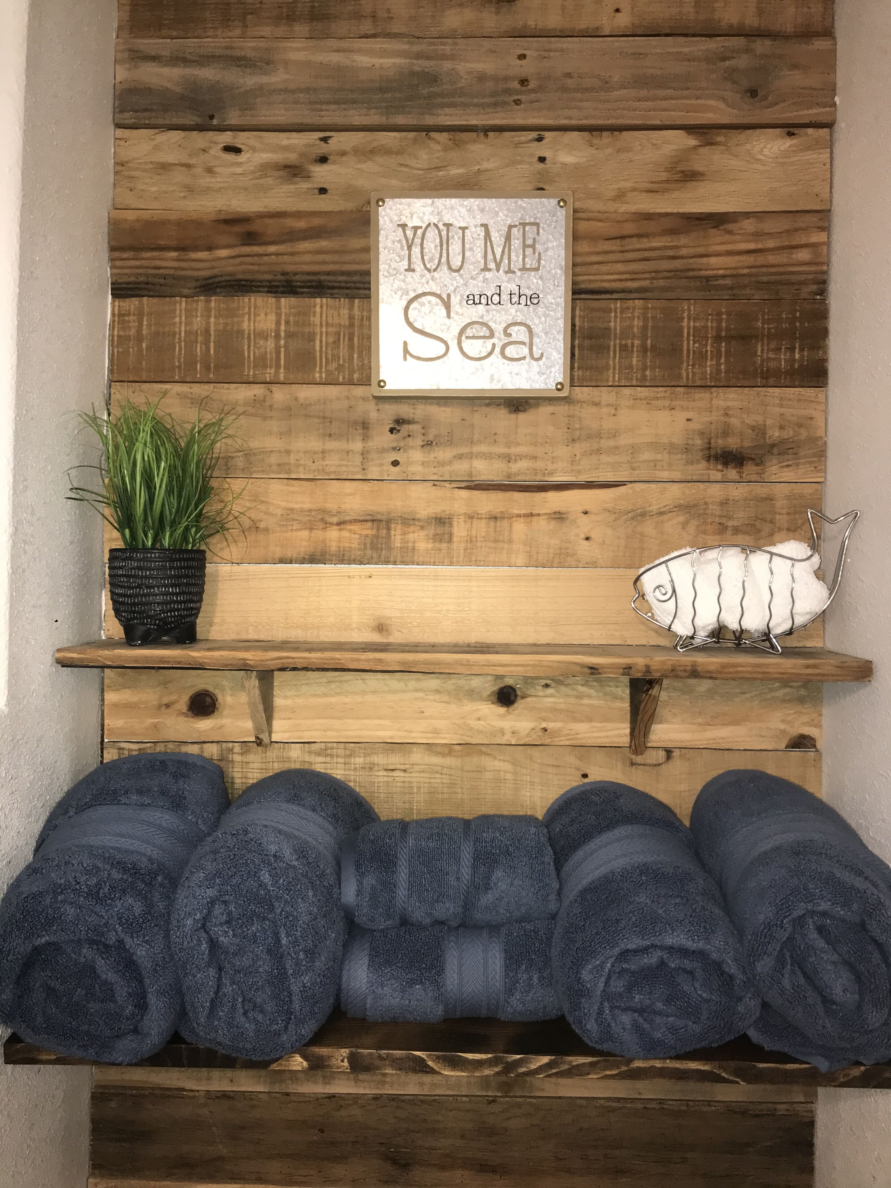 A wooden wall with a sign that reads 'YOU ME AND THE SEA'.