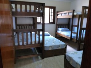 Une chambre avec des lits superposés, des rampes en bois et une fenêtre donnant sur un beau paysage.