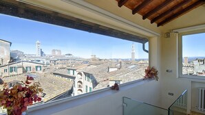 A balcony with a view of a cityscape, including buildings and a tower. - Rinidia Siena Centro (Siena)