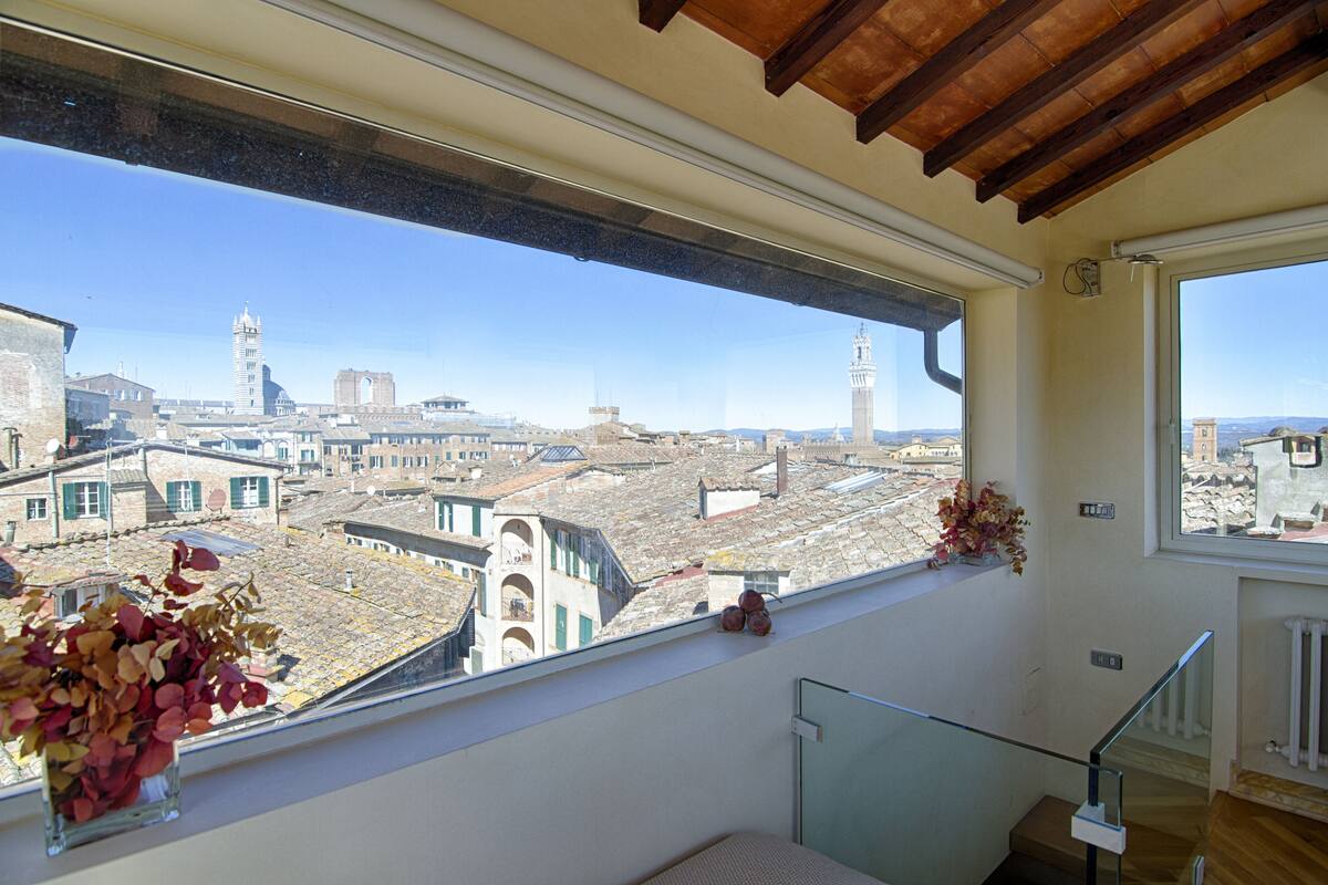 Un balcón con vistas a un paisaje urbano, incluyendo edificios y una torre.