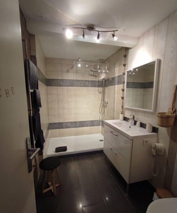 Une salle de bain moderne équipée d’une douche, d’une baignoire et d’un meuble-lavabo avec un miroir.