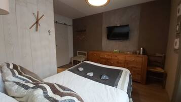 Ein Schlafzimmer mit Bett, Kommode und Fernseher.