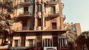 A multi-story building with balconies, a Redline sign, and satellite dishes. - Bella Casa Hostel (Cairo)