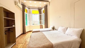 A bedroom with two beds, a wooden wardrobe, and a window with curtains. - Bella Casa Hostel (Cairo)