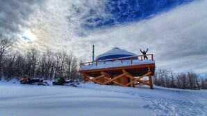 Una struttura di legno coperta di neve con una persona in piedi su una piattaforma.
