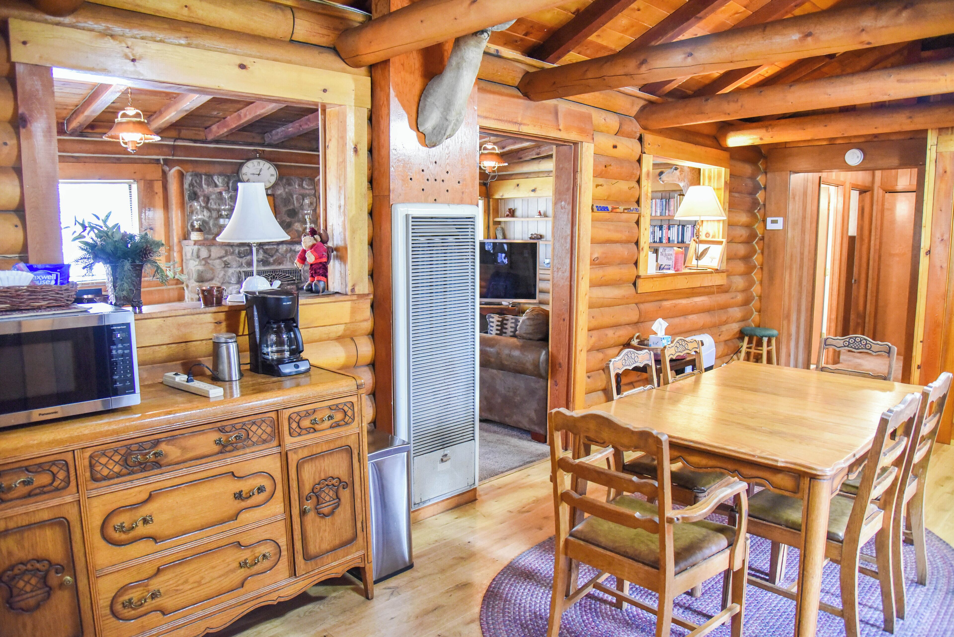 Ein Holzblockhaus mit Essbereich, Küche und Wohnbereich.
