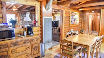 Ein Holzblockhaus mit Essbereich, Küche und Wohnbereich.