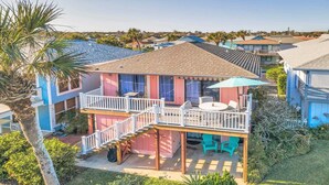A two-story house with a balcony, a pool, and a patio area with outdoor furniture. - Surf Crest Village #25 (Pelican Beach View) Ocean front 4 bedroom One pet only (ST. AUGUSTINE)