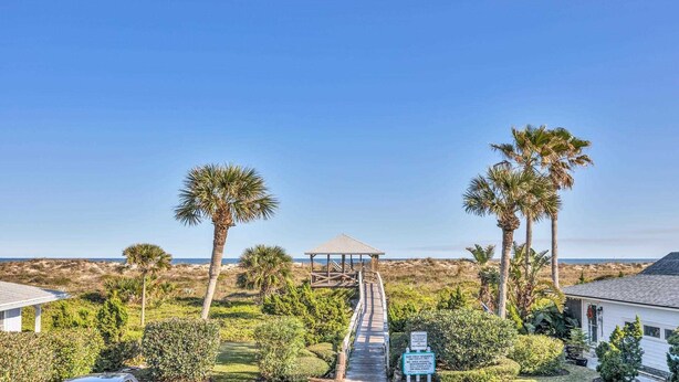 A pathway leading to a beach house with a gazebo, surrounded by palm trees and a clear view of the ocean. - Surf Crest Village #25 (Pelican Beach View) Ocean front 4 bedroom One pet only (ST. AUGUSTINE)