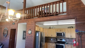 A kitchen with wooden cabinets, stainless steel appliances, and a wooden staircase. - Valley View in the Upper Valley (Red River)