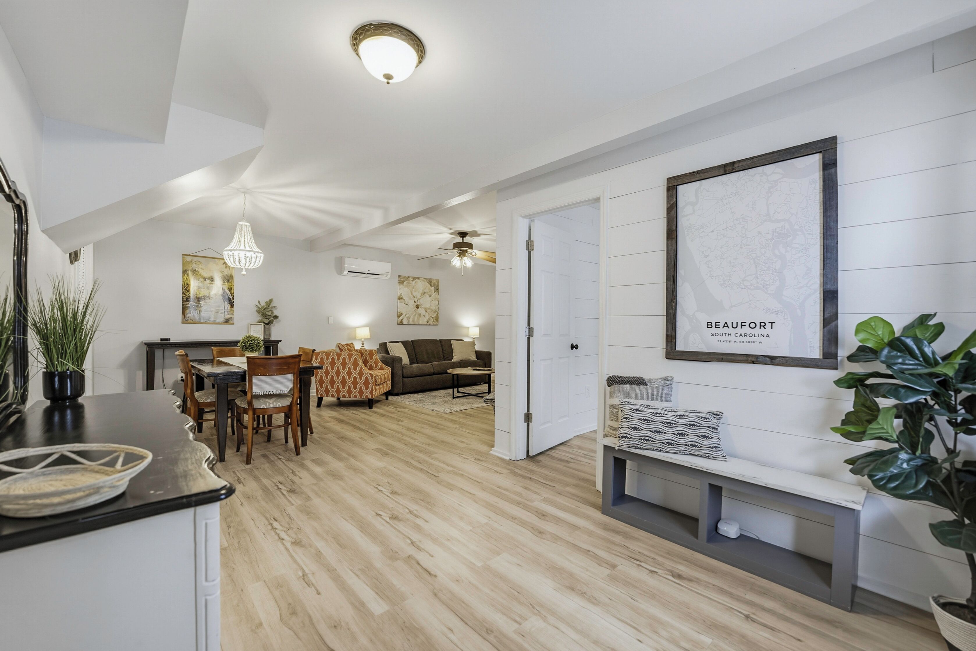 A modern interior with a dining area, a sofa, a bench, and a map on the wall.