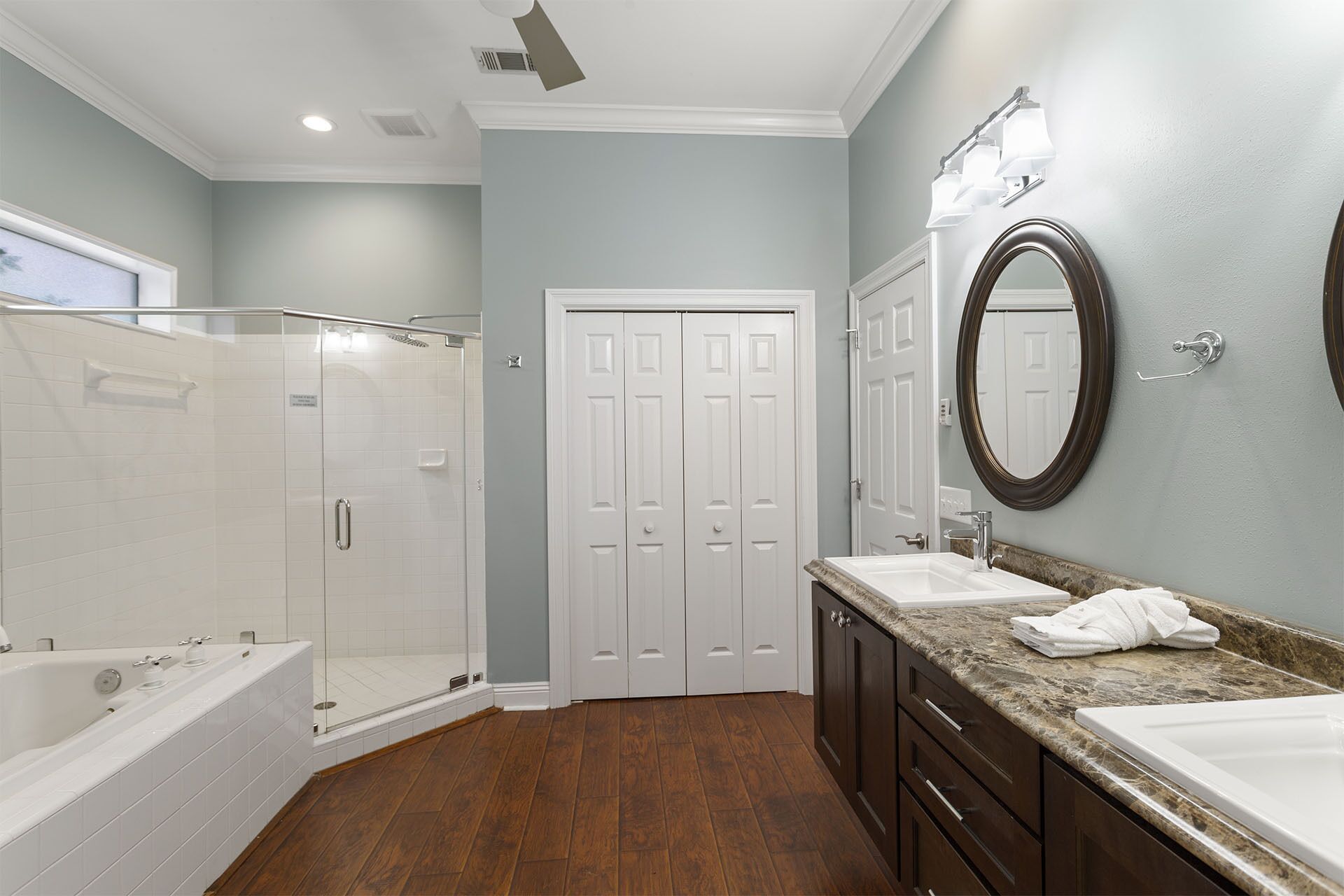 Un bagno moderno con doccia a ingresso diretto, vasca da bagno, mobile lavabo e specchio.