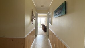 Un corridoio con rivestimenti in legno sulle pareti e pavimento piastrellato.