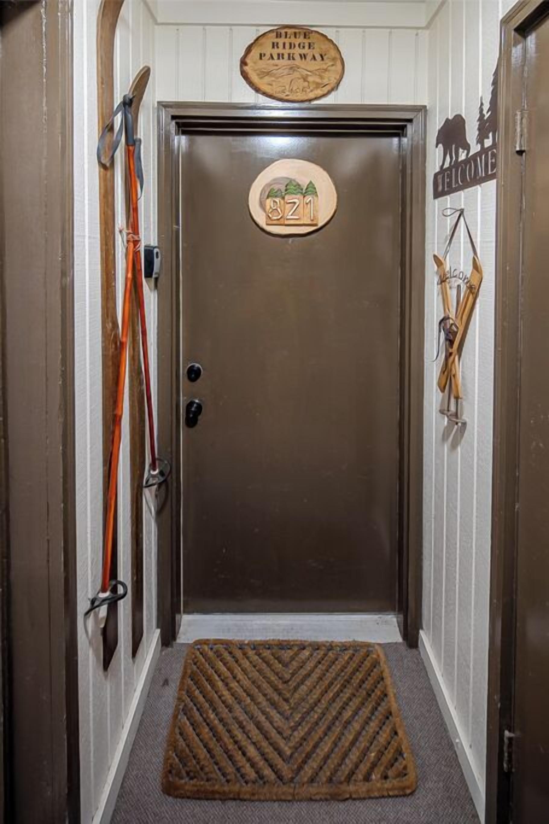 A door with a sign reading "Blue Ridge Parkway" and "Welcome" with a welcome mat in front.