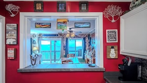 A red-walled room with a view of a balcony, framed artwork, and a welcome sign. - Sugar Ski Premium Two Bedroom - Unit 821 (Sugar Mountain)