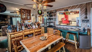 A rustic kitchen with wooden furniture, a dining table, and a bar area. - Sugar Ski Premium Two Bedroom - Unit 821 (Sugar Mountain)