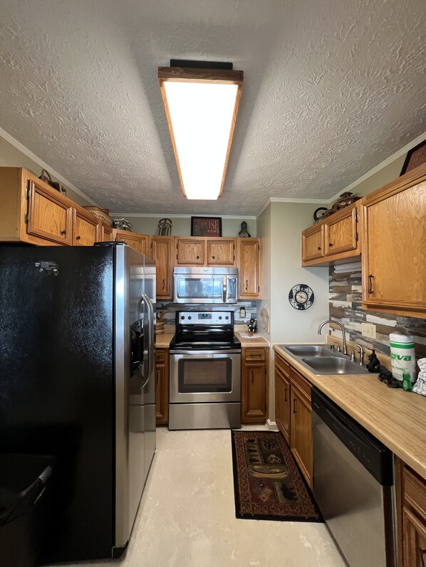 Enjoy cooking in this well-equipped kitchen with a central island, stainless steel appliances, and dishwasher.