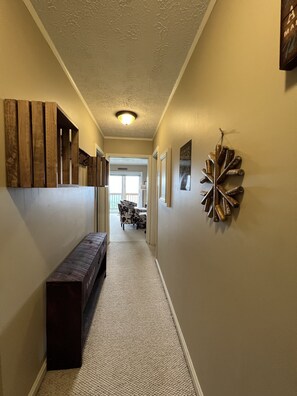 Stroll through this serene hallway to a dining area with a table and chairs.