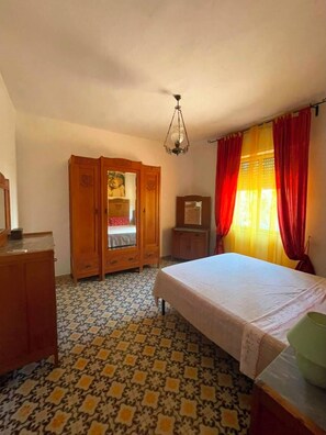 A bedroom with a bed, wardrobe, dresser, and a chandelier. - House / Villa - Perd'e'Sali (Pula)