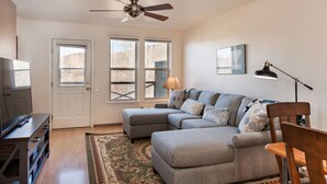 A living room with a sectional sofa, a television, a ceiling fan, and a large window. - Lakeside Home w/Views Near Basalt, 18 Mi. to Aspen (Basalt)