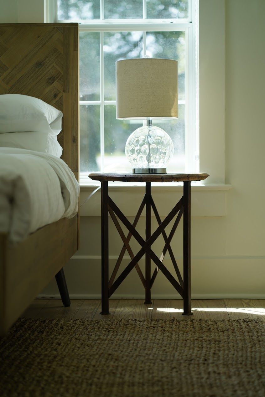 Una camera da letto con un letto, una lampada su un comodino e una finestra vista.