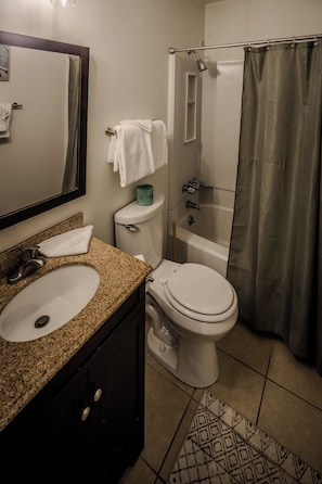 Un bagno con lavandino, toilette e doccia.