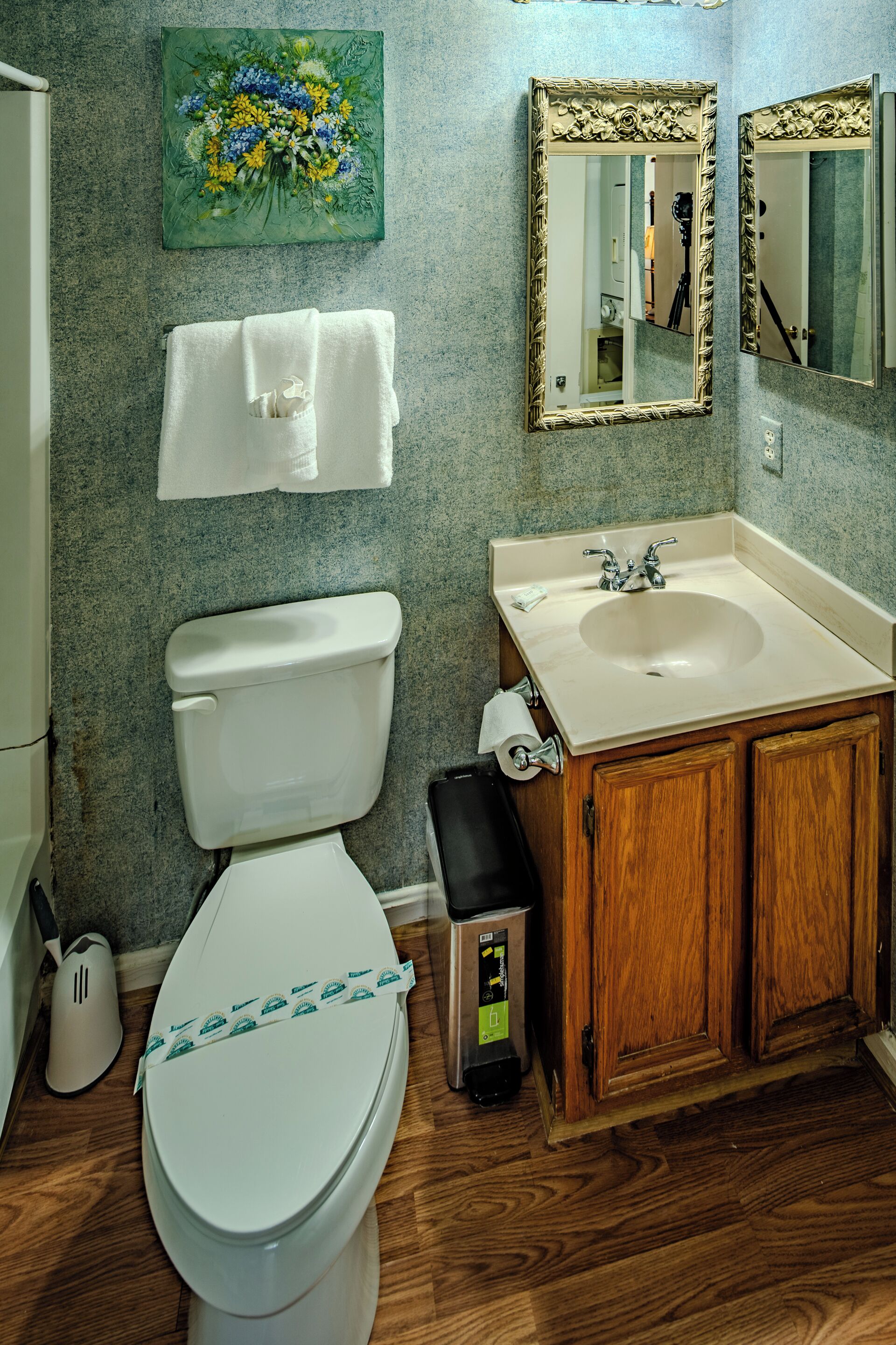 Un baño con inodoro, lavabo y armarios de madera.