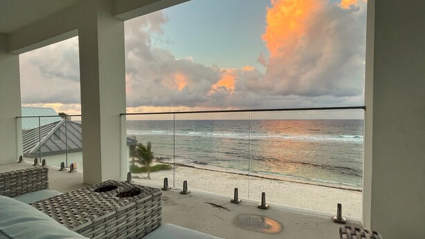 A balcony with a view of the ocean and beach.