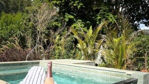 Una piscina con una botella de vino y una toalla en el borde.