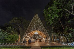 A large, open-air structure with a thatched roof, surrounded by lush greenery. - Lapalapa Beachfront (Cahuita)