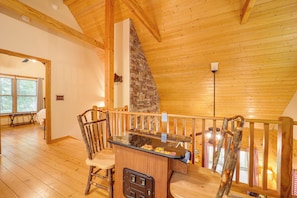 Cozy room with a stone fireplace, wooden bench, and glass-top table.