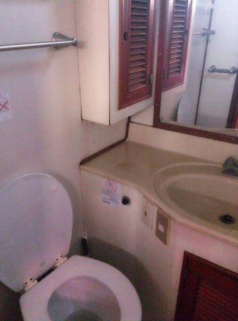 Un baño pequeño con inodoro, lavamanos y espejo.
