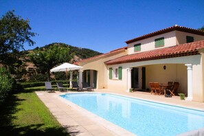 Relax by the pool in a villa with an outdoor space and lawn overlooking the hillside.