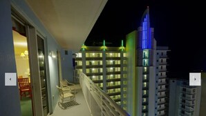 A balcony with a view of high-rise buildings at night. - 1 Bd Condo, Wide Open Ocean F U N! Atlantic_1BD (Daytona Beach)