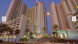 A high-rise hotel with multiple floors, a prominent entrance, and a well-lit facade. - 1 Bd Condo, Wide Open Ocean F U N! Atlantic_1BD (Daytona Beach)