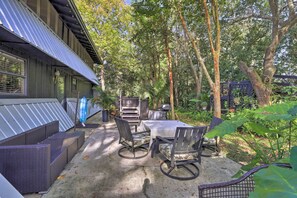 Enjoy dining or socializing in this serene patio area with a table, chairs, and grill.
