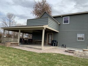 A two-story house with a covered patio area. - Farm House by River with trailer/RV parking(Pet Friendly including horses) (Brighton)