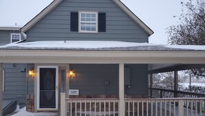 Une maison dotée d’un porche abrité, d’une enseigne accueillante et d’un toit recouvert de neige.