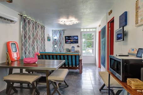 A dining area with a table, benches, a television, and a microwave.. Steps from the Beach & Bio Bay Tours in Esperanza