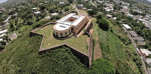 Explore the historic fort's circular central tower, surrounded by lush greenery and well-preserved architecture.
