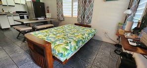 Cozy retreat with a single bed, desk, and kitchenette, perfect for a relaxing stay.