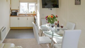 A modern kitchen with white cabinets, a microwave, and a window. - 2 bedroom accommodation in Bacton (Bacton)