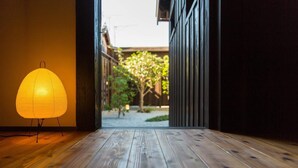 A wooden floor leading to an open doorway with a paper lantern on the left.