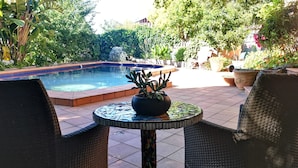 A pool area with a mosaic table and wicker chairs. - Stylish Comfortable Central Artists Home (Glen Waverley)