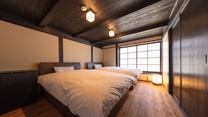 Une chambre avec un grand lit, un plancher en bois et une fenêtre donnant sur un beau paysage.