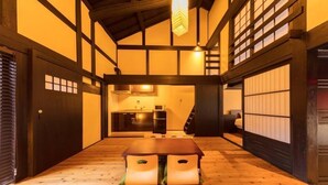 Une pièce de style japonais traditionnel, avec un sol recouvert de tatamis, une basse table en bois et des portes coulissantes.