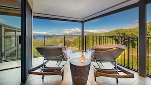 A balcony with wicker chairs, a table, and a bottle of champagne. - PICTURESQUE OCEAN VIEW CONDO - LAST MINUTE DEAL!  BEAUTIFUL WAILEA AT ELUA 2002 (Kihei)